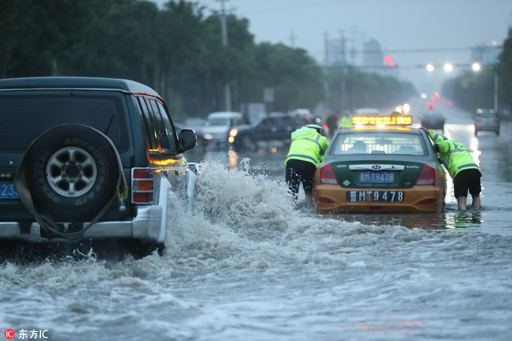 山西运城：暴雨如注马路内涝成海 交警水中推车如推船