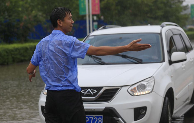 河南淮阳暴雨致段路积水成河 男子冒雨拦车