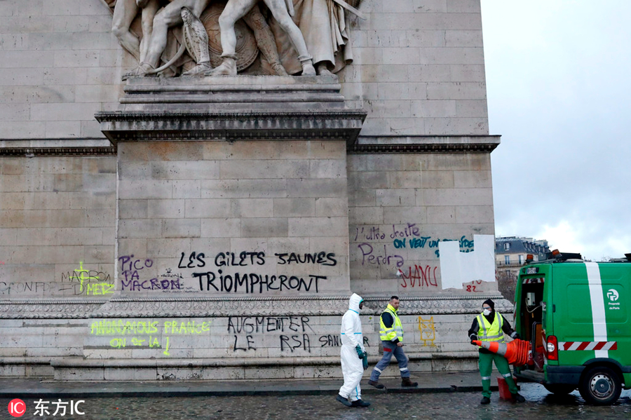 当地时间2018年12月2日，法国巴黎，“黄背心”示威骚乱过后，巴黎街头一片狼藉，工作人员清理凯旋门上的涂鸦。图为东方IC版权作品  请勿转载