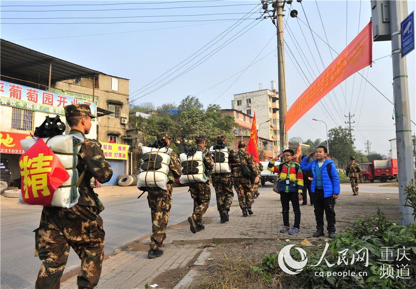 图为小学生向拉练官兵致敬 王肸 摄